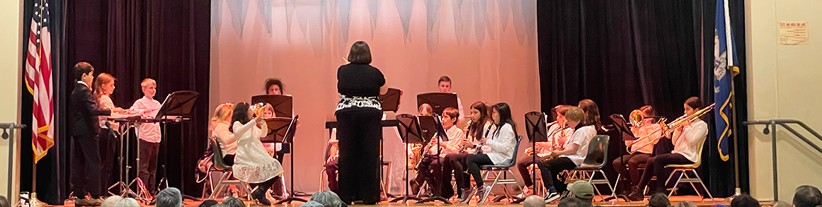 Students performing on stage with teacher